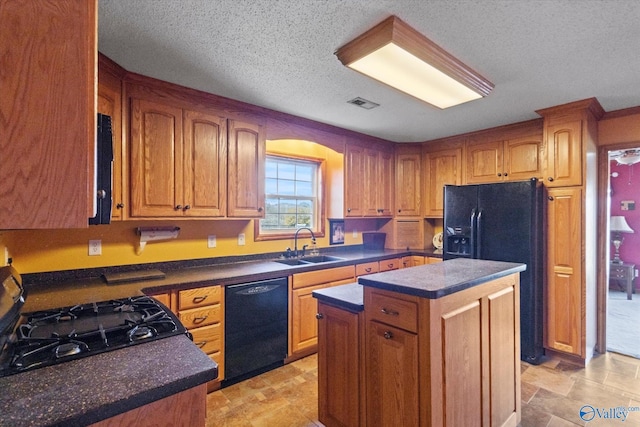 kitchen featuring a center island, black appliances, a textured ceiling, and sink