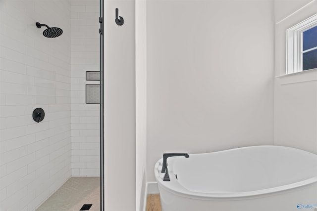 full bathroom with a shower stall and a soaking tub