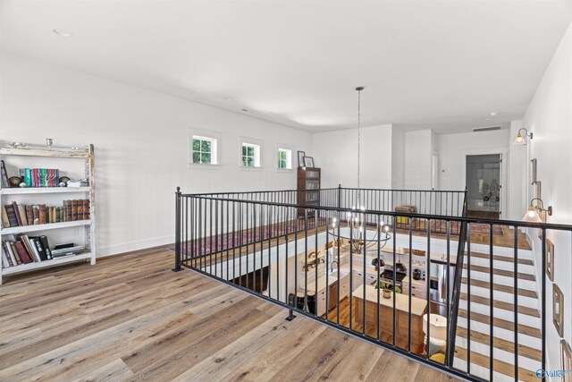 hall featuring hardwood / wood-style flooring and a chandelier