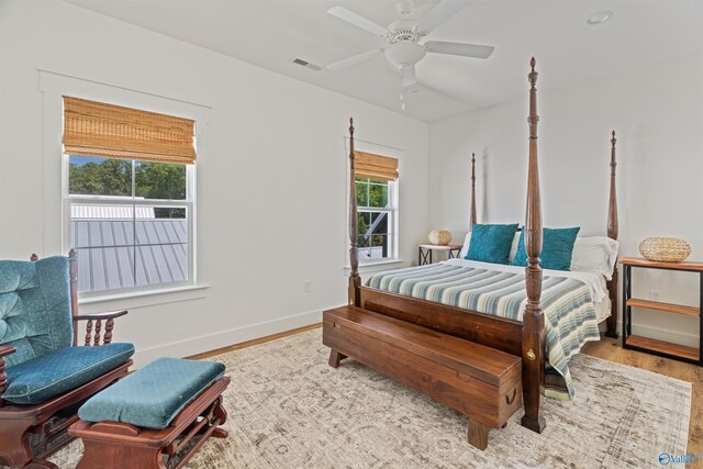 bedroom featuring ceiling fan, multiple windows, and light hardwood / wood-style flooring