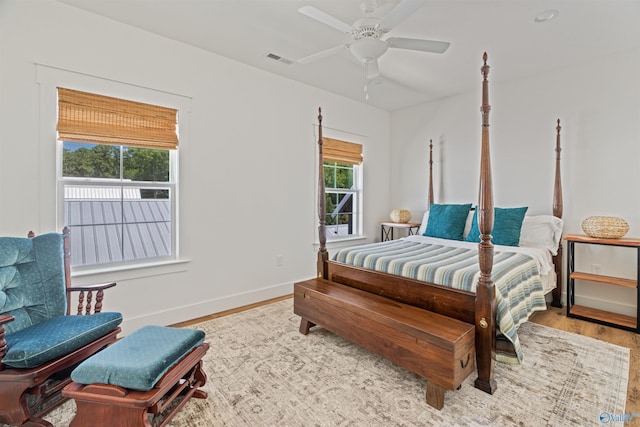 bedroom with ceiling fan, wood finished floors, visible vents, and baseboards