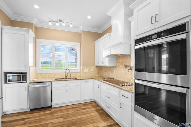 kitchen with crown molding, a sink, white cabinetry, and stainless steel appliances
