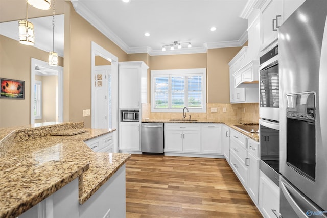 kitchen featuring crown molding, a sink, white cabinetry, and stainless steel appliances