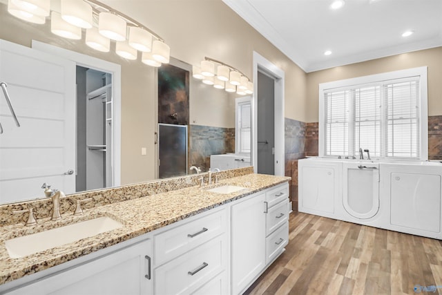 bathroom featuring double vanity, a sink, wood finished floors, and ornamental molding