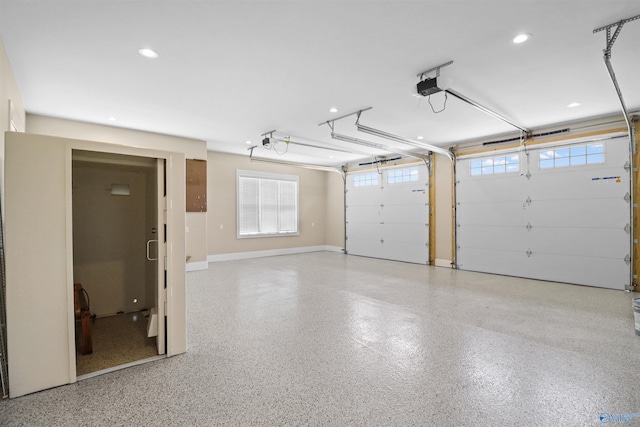 garage featuring baseboards, a garage door opener, and recessed lighting