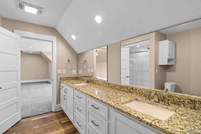 bathroom featuring an enclosed shower, visible vents, a sink, and wood finished floors