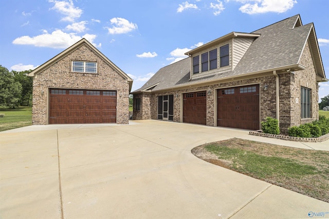 view of front of property with concrete driveway, brick siding, and roof with shingles
