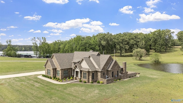 exterior space with a lawn, a water view, stone siding, and brick siding