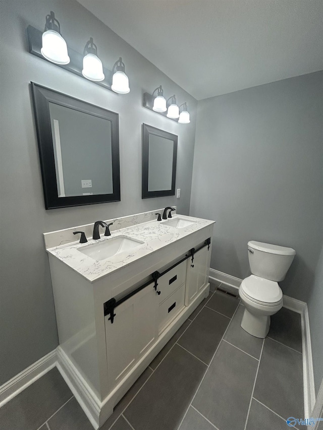 bathroom with tile patterned flooring, a sink, and baseboards