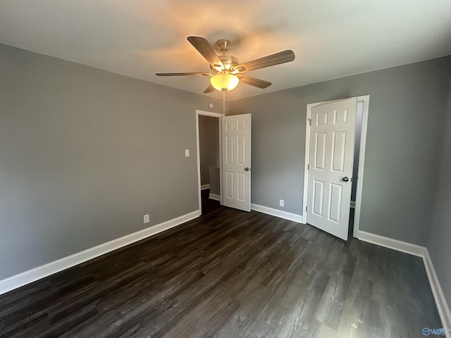 unfurnished bedroom with dark wood-style flooring, a ceiling fan, and baseboards