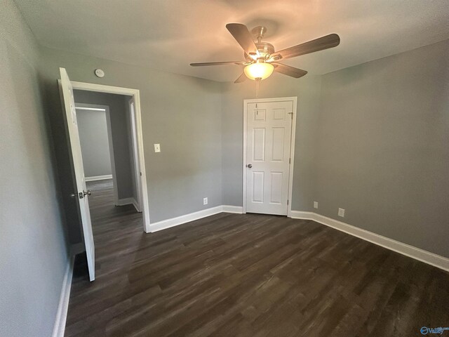 unfurnished bedroom with dark wood finished floors, a ceiling fan, and baseboards