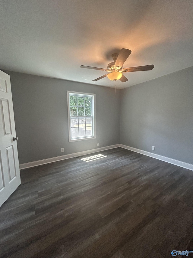 unfurnished room with ceiling fan, baseboards, and dark wood finished floors