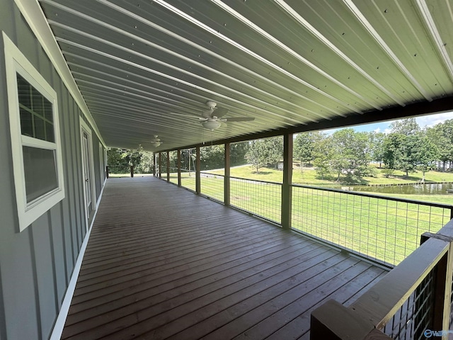 wooden deck with ceiling fan, a carport, and a lawn