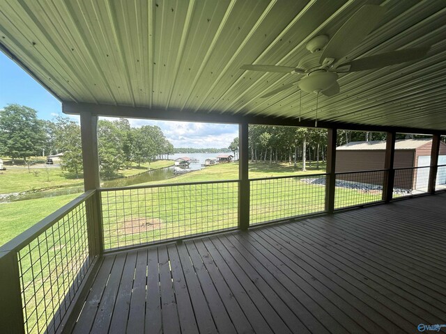 wooden deck featuring a ceiling fan and a lawn