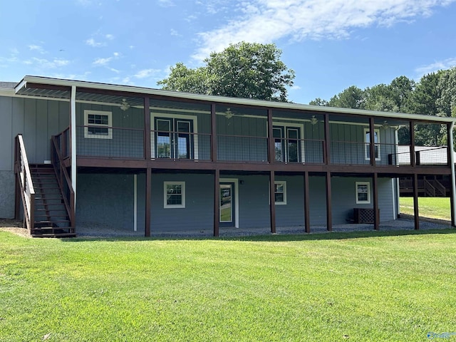 back of house featuring a lawn, stairs, a deck, cooling unit, and board and batten siding