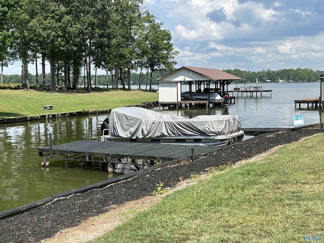 dock area featuring a water view, boat lift, and a yard