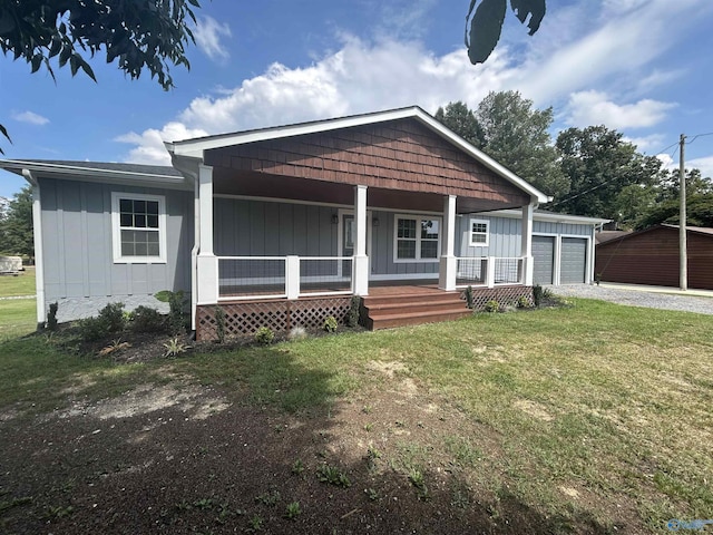 view of front of house featuring an attached garage, a porch, board and batten siding, and a front yard