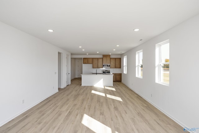 kitchen featuring a kitchen island with sink, sink, and light hardwood / wood-style floors