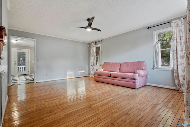 living room featuring light wood-type flooring, a textured ceiling, and ceiling fan