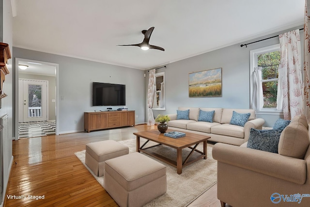 living room with ornamental molding, ceiling fan, and light hardwood / wood-style flooring