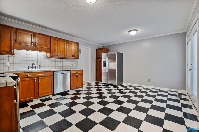 kitchen featuring appliances with stainless steel finishes, sink, crown molding, and backsplash