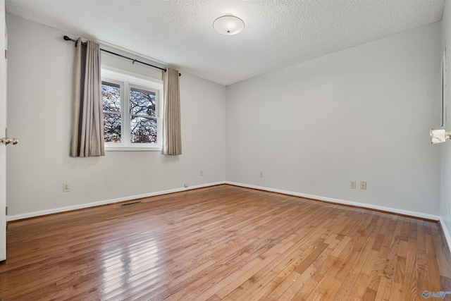 spare room with hardwood / wood-style flooring and a textured ceiling