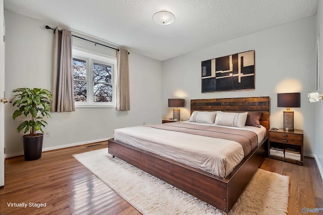 bedroom featuring a textured ceiling and hardwood / wood-style flooring