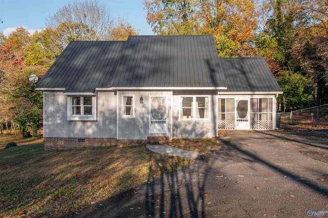 view of front of house with a sunroom and a front lawn