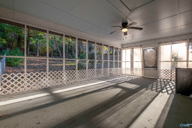 unfurnished sunroom featuring ceiling fan