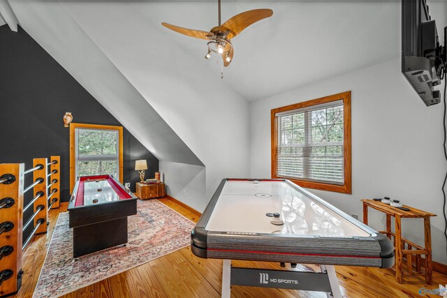 game room featuring wood-type flooring, ceiling fan, vaulted ceiling, and a wealth of natural light