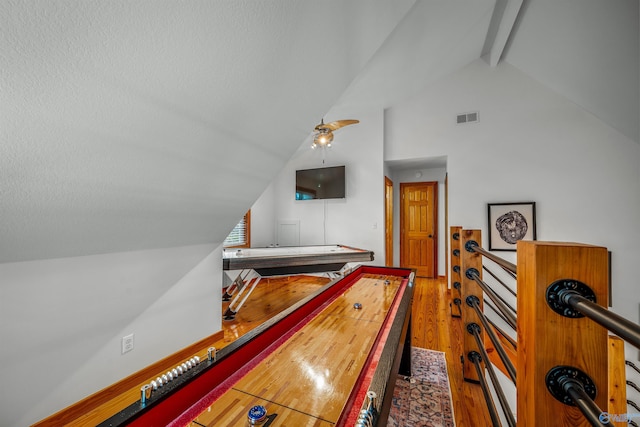 playroom with vaulted ceiling with beams and wood-type flooring