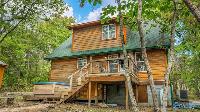 rear view of house with cooling unit and a deck