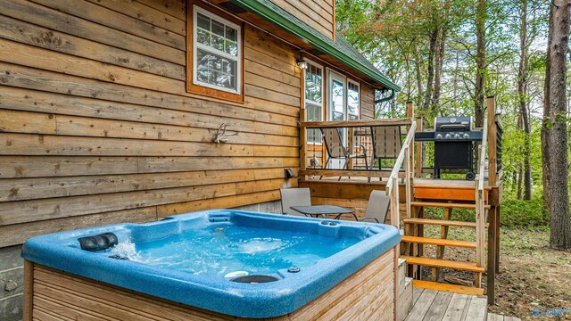 wooden terrace with area for grilling and a hot tub