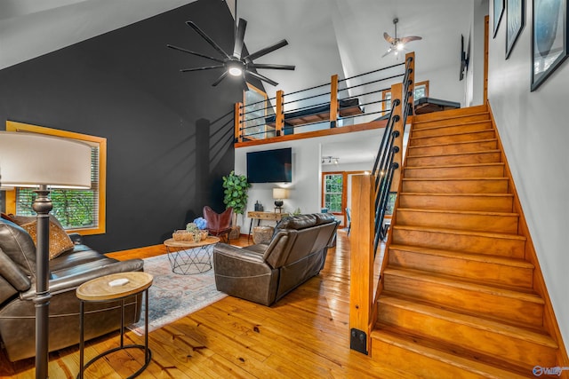 living room featuring ceiling fan, light hardwood / wood-style floors, and high vaulted ceiling