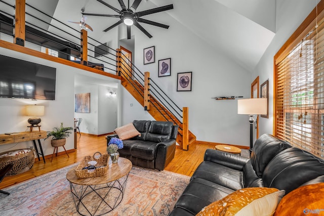 living room with ceiling fan, light hardwood / wood-style flooring, and high vaulted ceiling