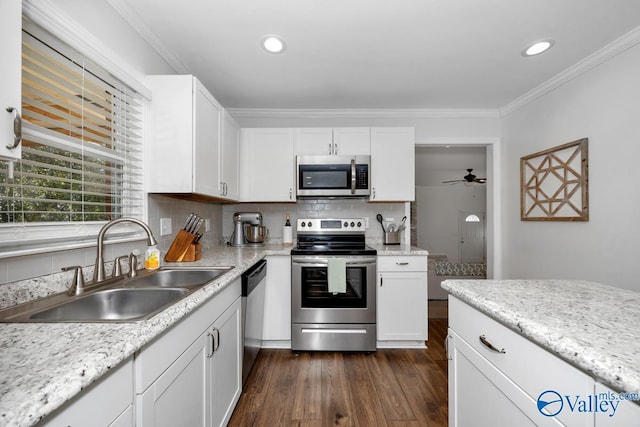 kitchen featuring white cabinetry, ornamental molding, appliances with stainless steel finishes, and sink