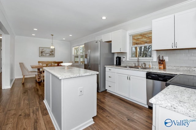 kitchen featuring sink, appliances with stainless steel finishes, hanging light fixtures, a center island, and white cabinets