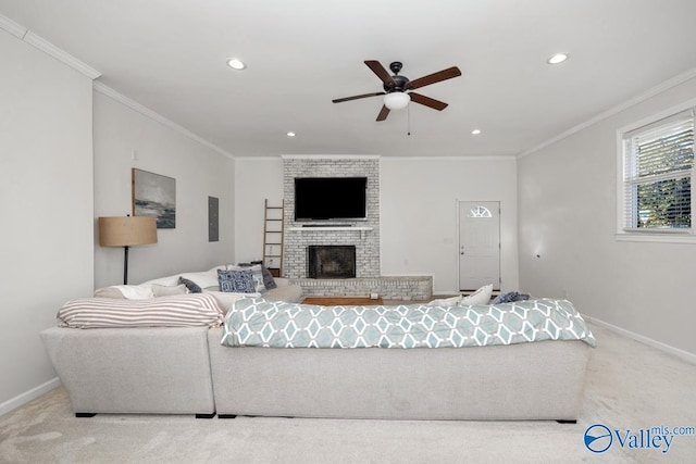 living room featuring crown molding, a brick fireplace, carpet flooring, and ceiling fan