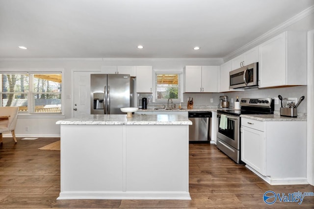 kitchen with stainless steel appliances, a center island, sink, and white cabinets