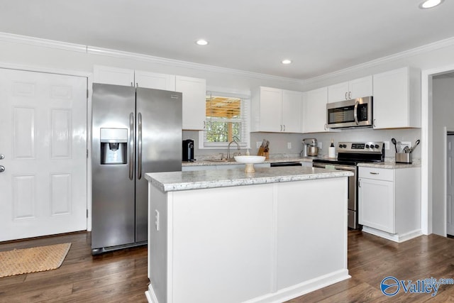 kitchen featuring sink, white cabinetry, stainless steel appliances, a kitchen island, and dark hardwood / wood-style flooring