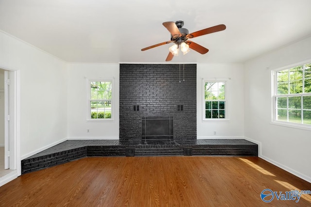 4407 Sparkman Dr NW, Huntsville, AL 35810 - unfurnished living room with crown molding, ceiling fan, wood finished floors, a brick fireplace, and baseboards