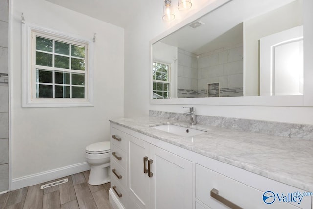 4407 Sparkman Dr NW, Huntsville, AL 35810 - full bath with toilet, wood finished floors, vanity, and visible vents