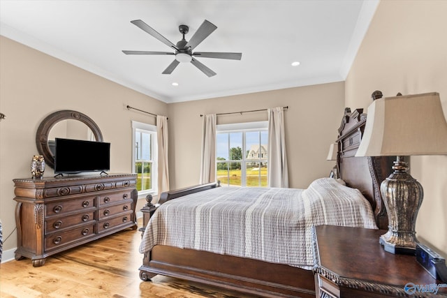 bedroom with light hardwood / wood-style floors, crown molding, and ceiling fan