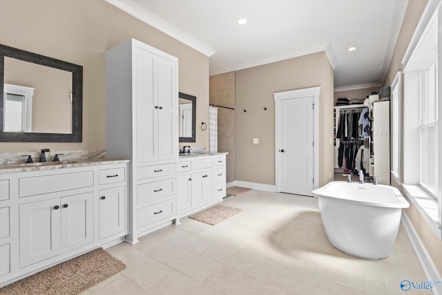 bathroom featuring crown molding, tile patterned floors, a tub to relax in, and vanity