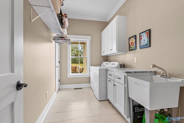 laundry room with light tile patterned flooring, ornamental molding, sink, separate washer and dryer, and cabinets