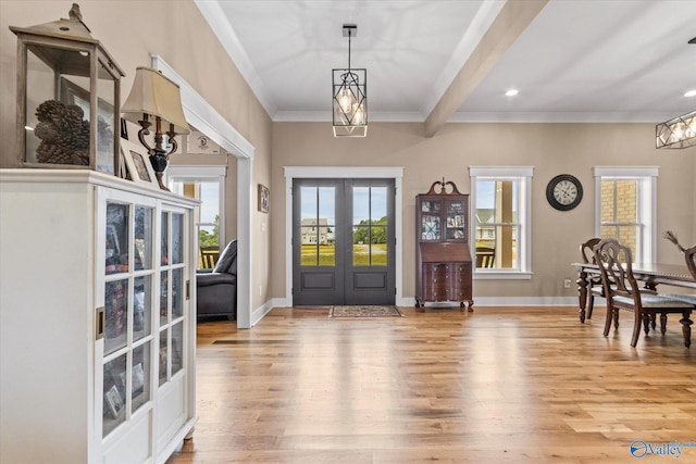 foyer featuring plenty of natural light, beamed ceiling, french doors, and light hardwood / wood-style flooring