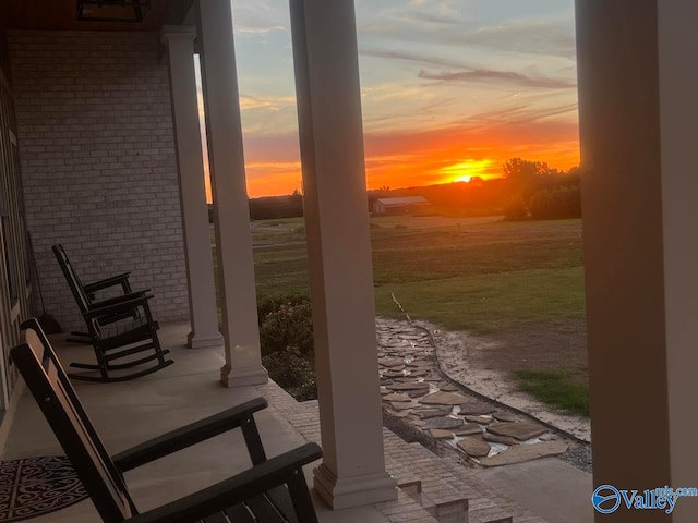 patio terrace at dusk featuring a porch