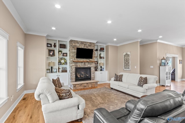 living room with light hardwood / wood-style floors, built in features, and a stone fireplace