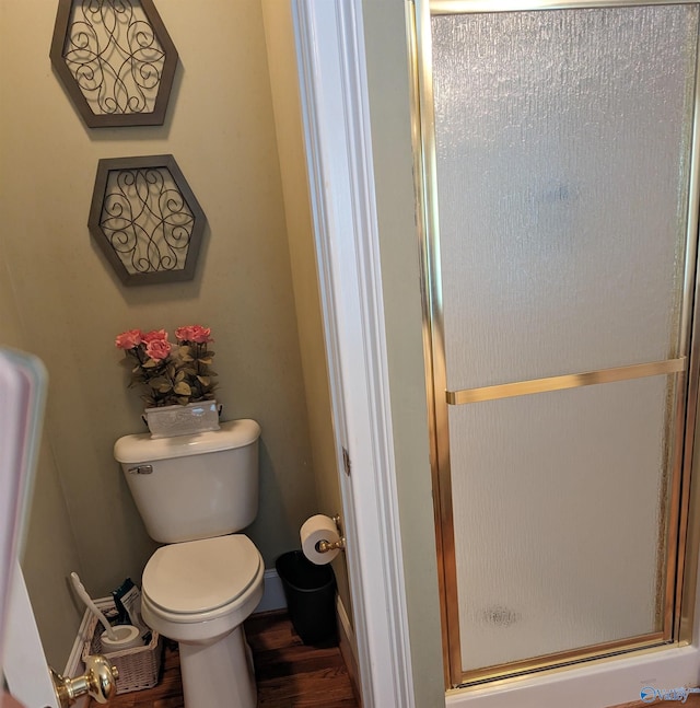 bathroom featuring an enclosed shower, wood-type flooring, and toilet