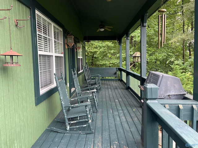 wooden deck with ceiling fan and a grill